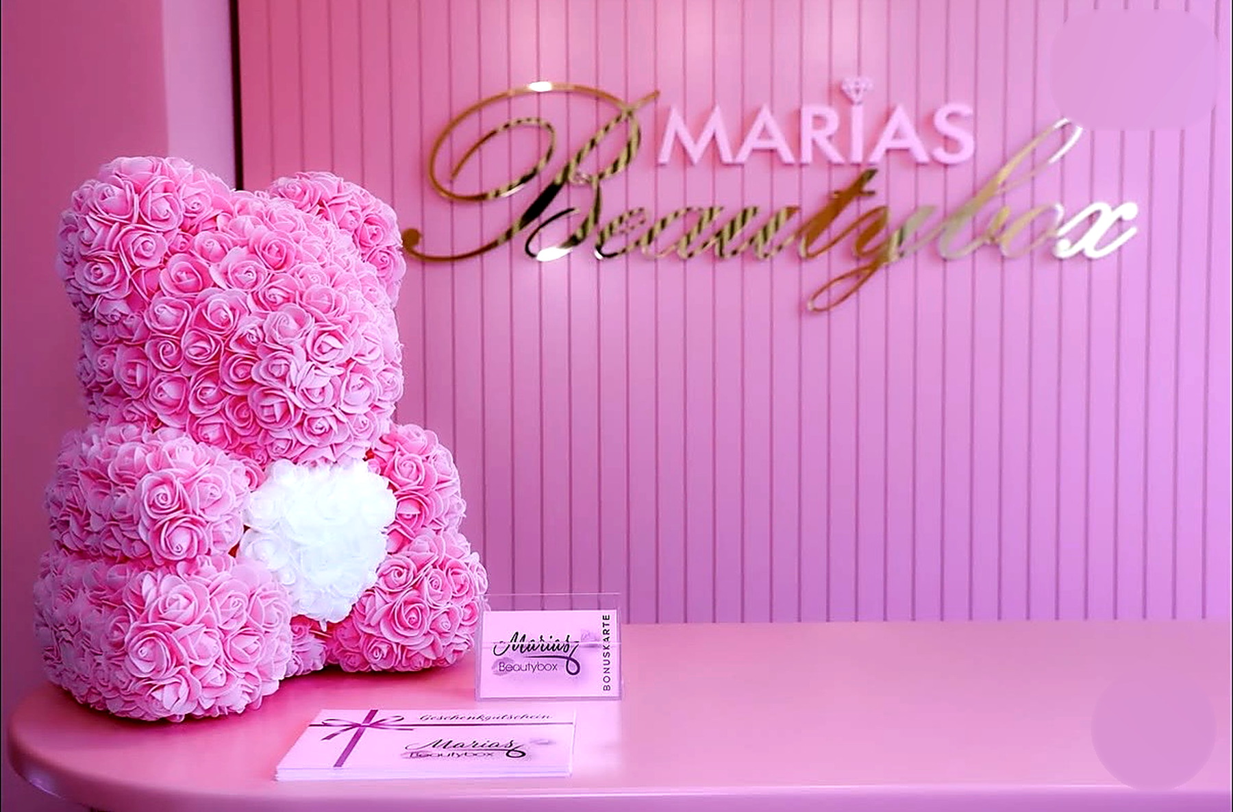Logo-Wand von Marias Beautybox mit Rosenbär